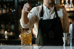 Bartender mixing cocktail in glass at bar