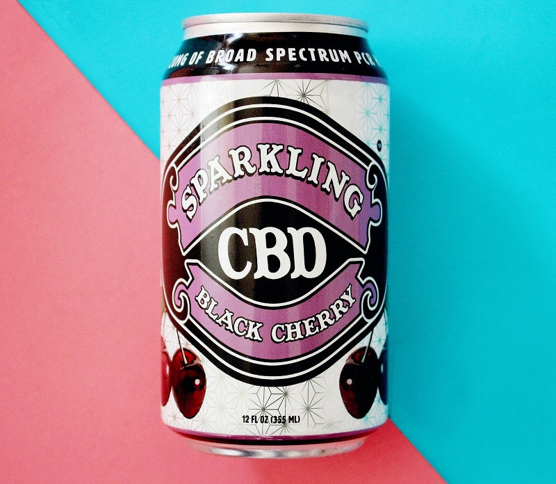 Black Cherry CBD Soda can against background evenly split into pink and blue colored halves