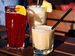 Long island iced tea, piña colada and white russian on outdoor wooden table