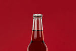 Top of glass soda bottle of cherry soda against red background