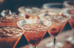 Mixed drinks in martini glasses lined on wooden bar