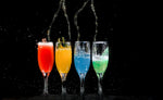 Multicolored mixed drinks in champagne flutes on bar
