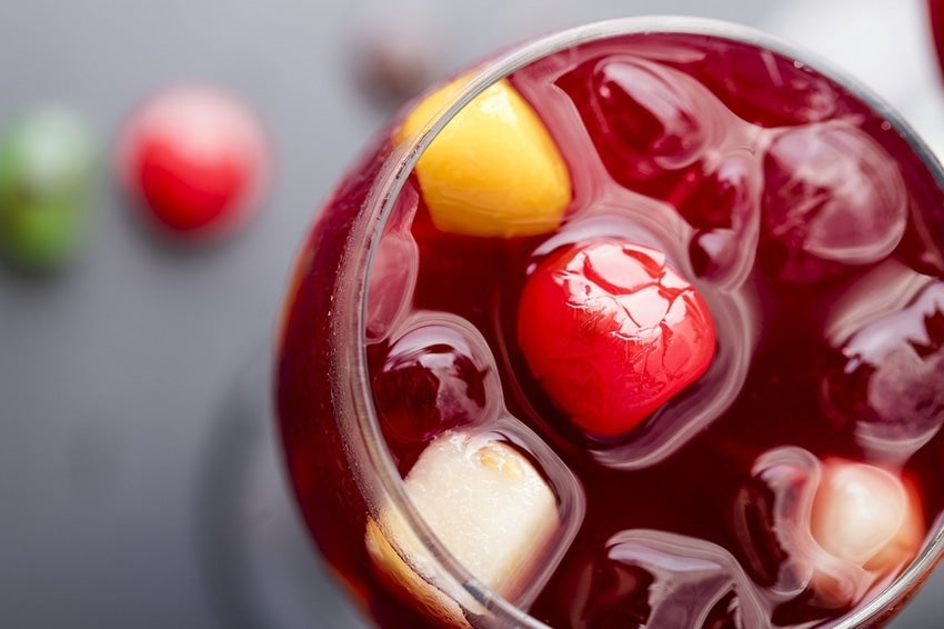 Full glass of sparkling red wine sangria from above with ice and fruit for garnish