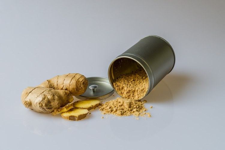 Ginger root and spilled ground ginger container