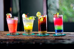 Mixed drinks in assorted glasses and colors on bar