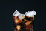 Glass of iced cola with dark background