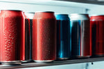 Red and blue aluminum soda cans on refrigerator shelf