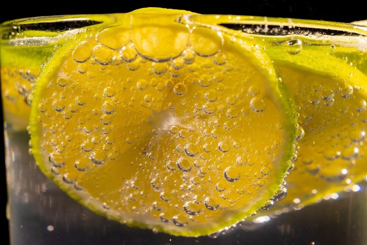Close-up view of sparkling water glass with lemon slice garnish