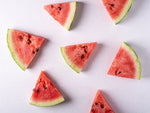 Watermelon slices in varied positions on flat white surface